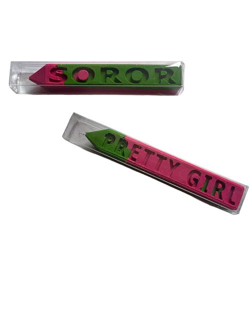 Two small clear plastic boxes containing pink and green crayons, each printed with the word 'SOROR' or 'PRETTY GIRL'