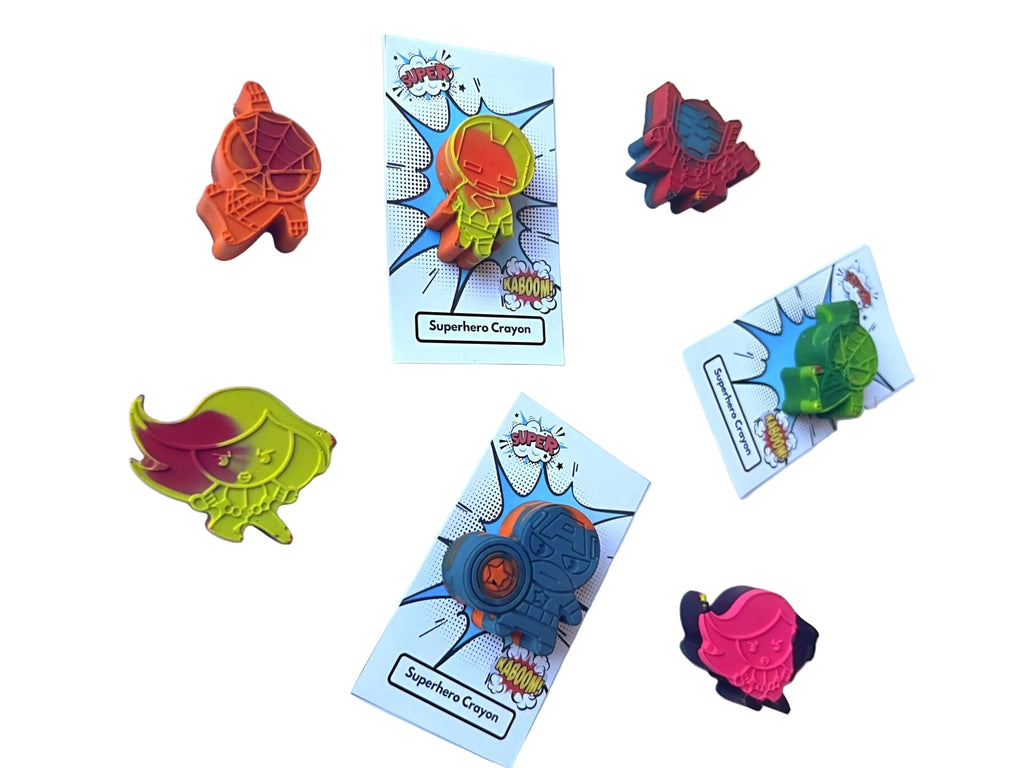 Colorful superhero crayon party favors on a white background